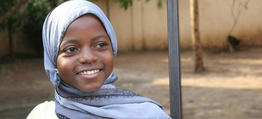 Girl smiling wearing a light blue hajib